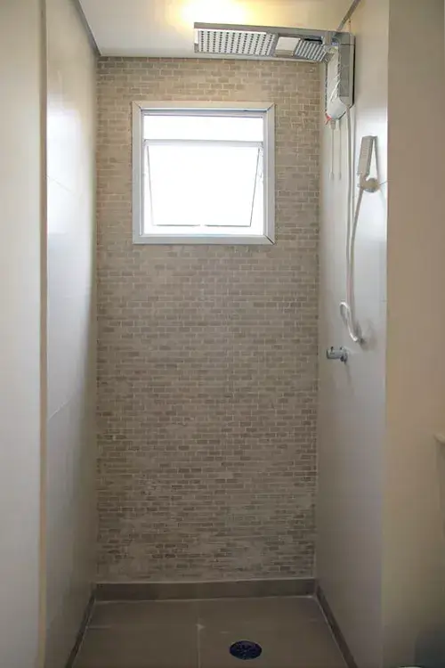 Banheiro com box revestido com pastilha tijolinho horizontal mosaico marmore crema Portinari Brick e porcelanato