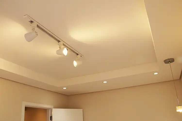 Forro com iluminação forro parcial de dormitório com iluminação projetada com embutidos, trilho com spots direcionáveis e pendentes