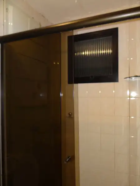 Banheiro antigo com box de vidro fumê e revestimento cerâmico Banheiro antigo com box de vidro fumê e revestimento cerâmico